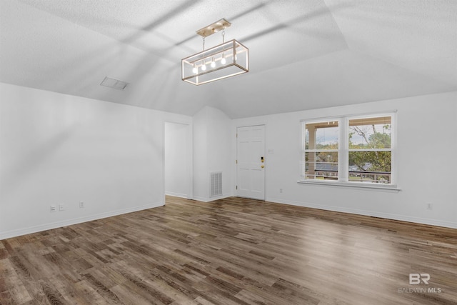 interior space featuring dark wood-type flooring and vaulted ceiling