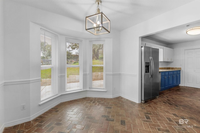 unfurnished dining area featuring a chandelier