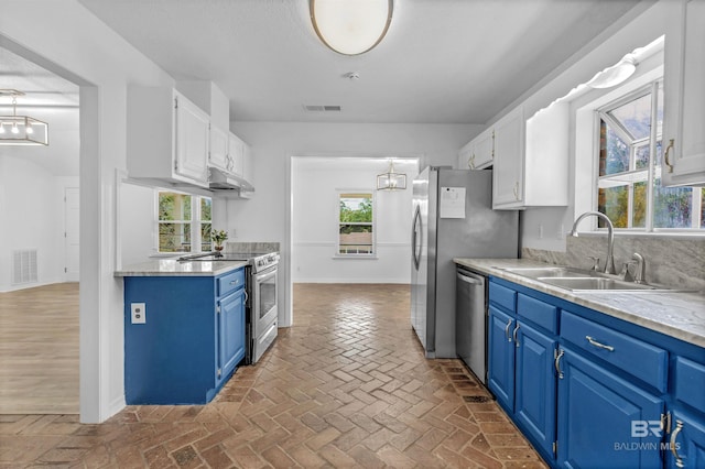 kitchen with blue cabinetry, sink, white cabinets, and stainless steel appliances