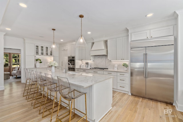 kitchen with white cabinets, appliances with stainless steel finishes, decorative backsplash, and custom range hood