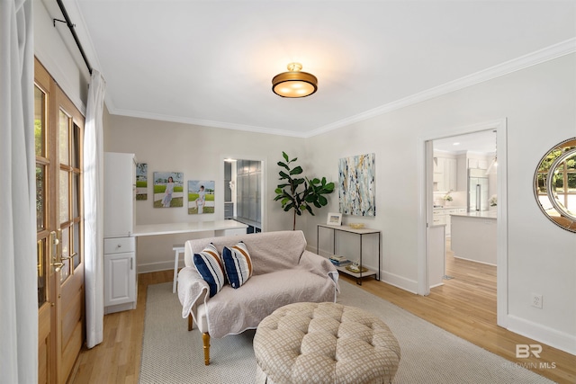 living area featuring baseboards, light wood-style floors, and ornamental molding