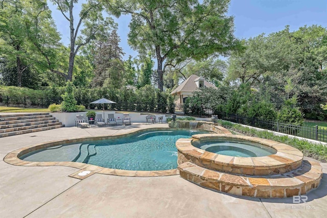 view of pool with fence, a patio area, and a pool with connected hot tub