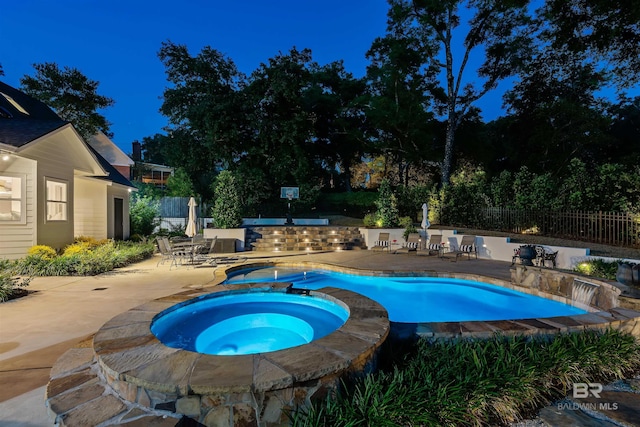 view of pool with fence, a patio area, a fenced in pool, and an in ground hot tub