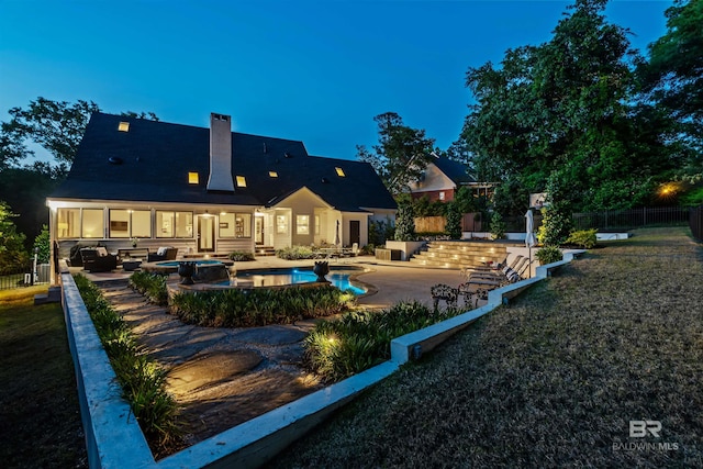 back of property with a chimney, fence, a patio, an outdoor living space, and a pool with connected hot tub