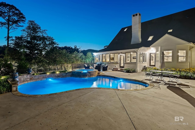 view of swimming pool featuring a pool with connected hot tub and a patio