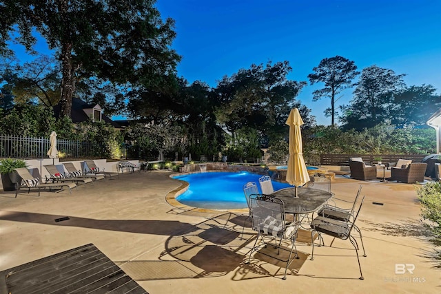 community pool featuring outdoor lounge area, a patio area, and fence