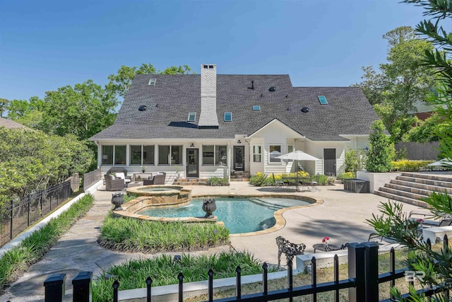 view of swimming pool featuring a fenced backyard, a pool with connected hot tub, and a patio