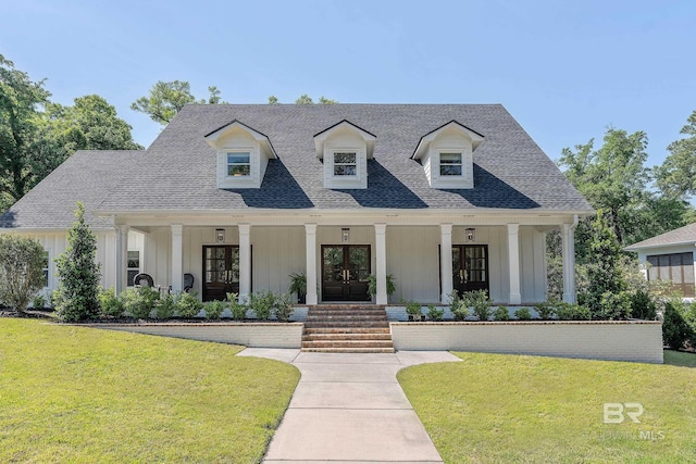cape cod house with board and batten siding, covered porch, french doors, and a front yard