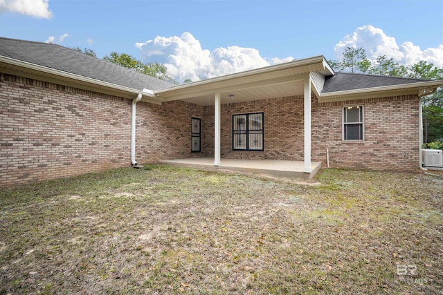 back of property featuring a patio area and a yard