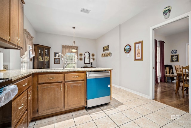 kitchen featuring electric range oven, sink, light tile patterned floors, pendant lighting, and dishwasher