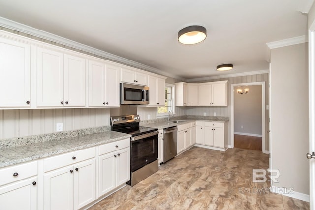 kitchen featuring white cabinets, appliances with stainless steel finishes, light stone countertops, crown molding, and a sink