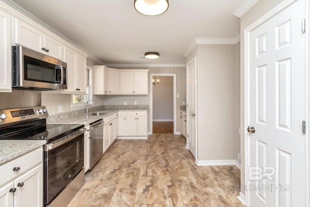 kitchen featuring crown molding, stainless steel appliances, a sink, and white cabinets