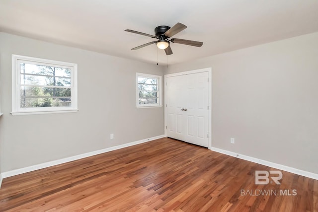 spare room with ceiling fan, wood finished floors, and baseboards