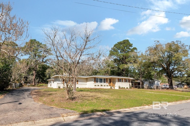 ranch-style house featuring a front lawn, an attached garage, and aphalt driveway