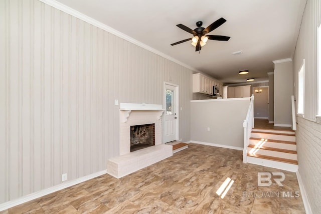 unfurnished living room with a ceiling fan, a brick fireplace, a healthy amount of sunlight, and crown molding