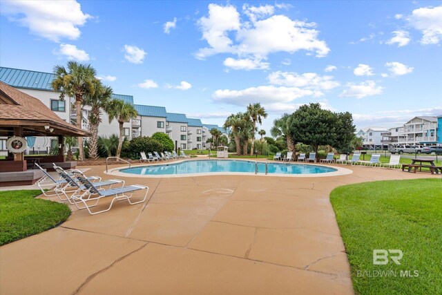 view of pool featuring a yard and a patio