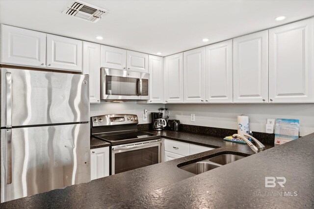 kitchen with stainless steel appliances, sink, and white cabinets