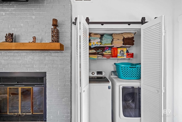 washroom featuring independent washer and dryer and brick wall