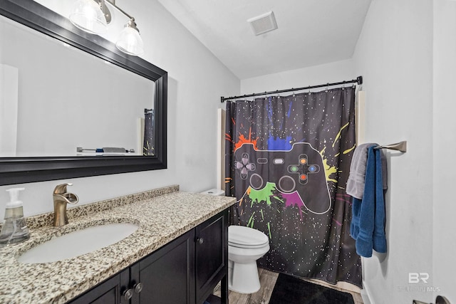 bathroom featuring toilet, wood-type flooring, vanity, and walk in shower