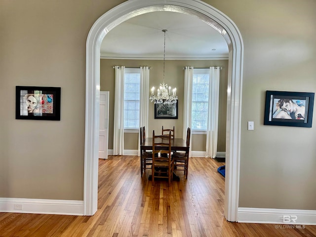 dining area with a healthy amount of sunlight, an inviting chandelier, and hardwood / wood-style floors