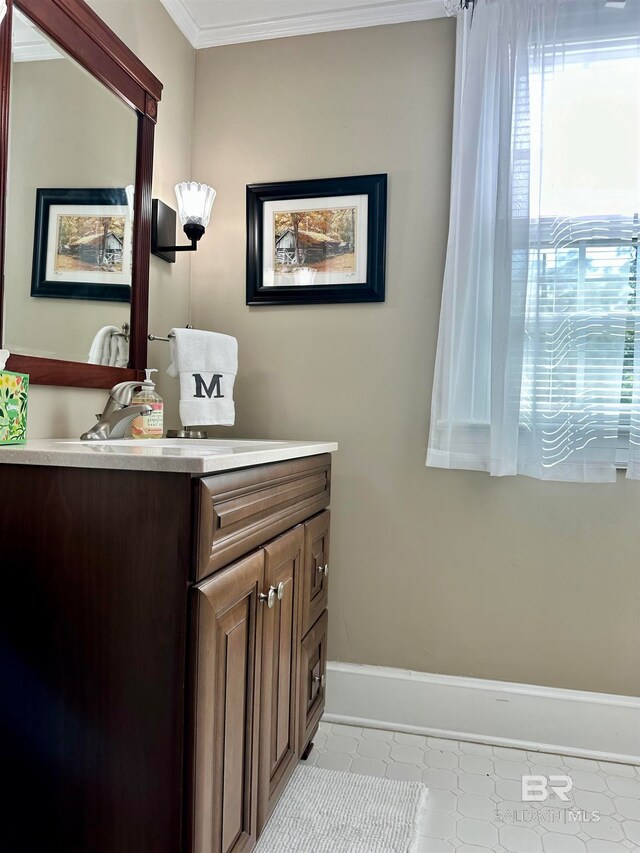 bathroom featuring tile patterned floors, crown molding, and vanity