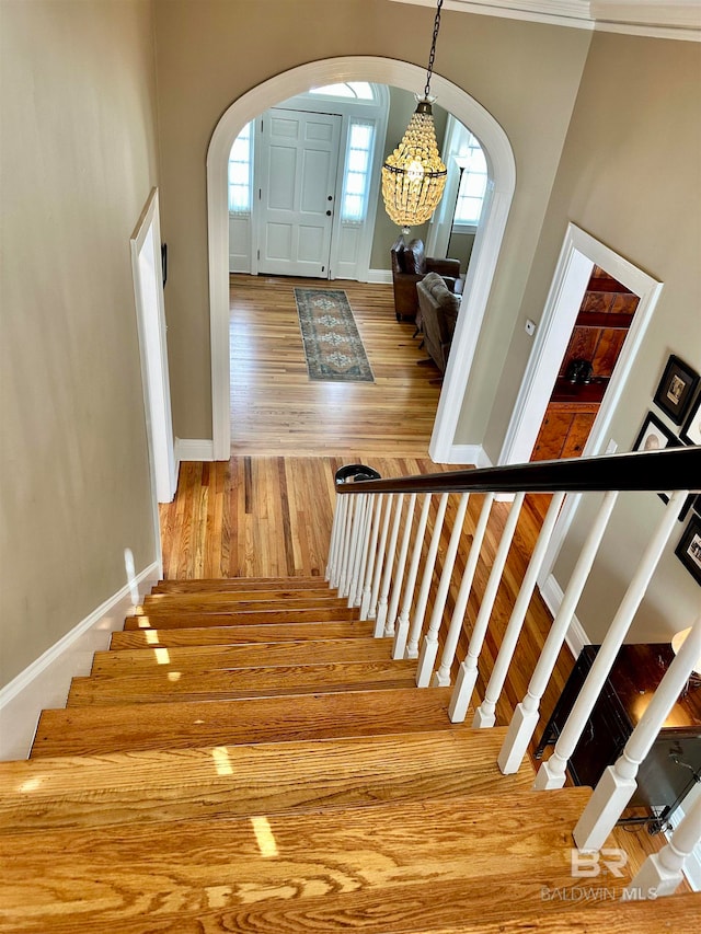 stairway featuring light hardwood / wood-style floors and a towering ceiling