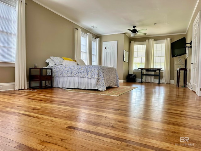 bedroom featuring crown molding, light wood-type flooring, and ceiling fan