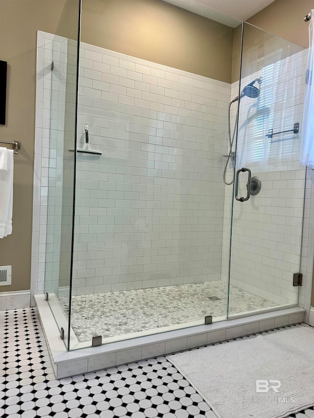 bathroom with a shower with door and tile patterned flooring