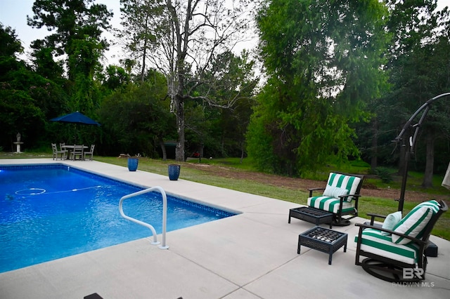 view of swimming pool featuring a patio and a yard