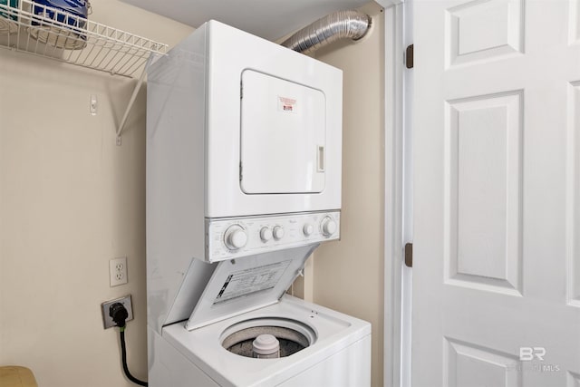 clothes washing area with stacked washer and dryer and laundry area