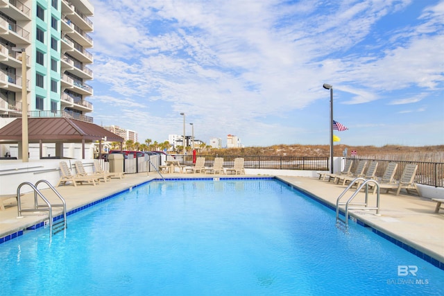 community pool with fence and a patio