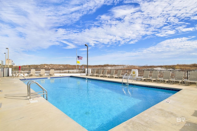 pool with a patio and fence