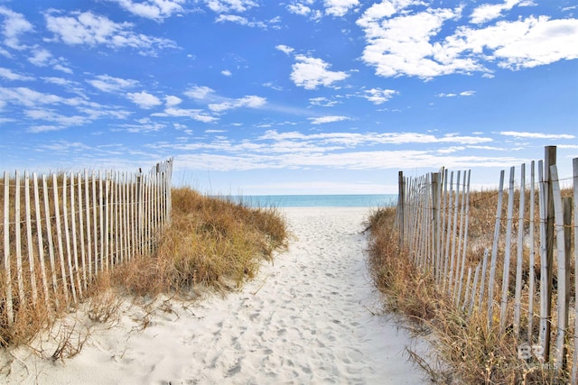 water view with a beach view and fence