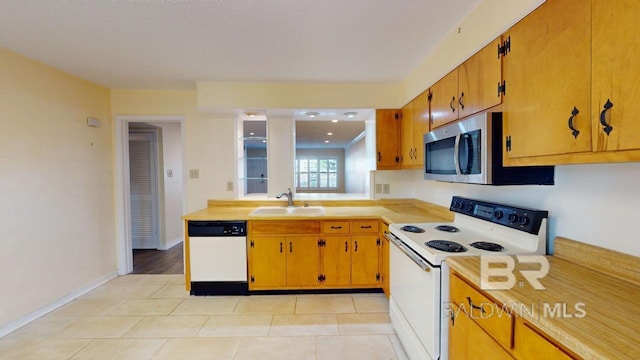 kitchen featuring sink, light tile patterned floors, and white appliances