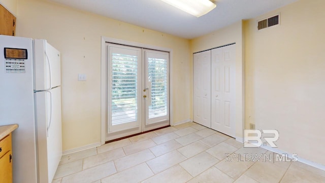 entryway featuring french doors and light tile patterned floors