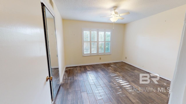 unfurnished bedroom with a closet, ceiling fan, dark hardwood / wood-style flooring, and a textured ceiling