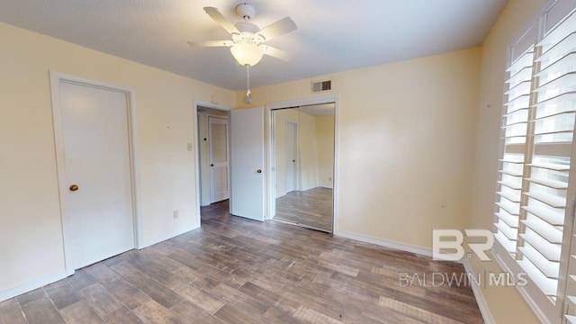 unfurnished bedroom featuring ceiling fan, a closet, and dark hardwood / wood-style floors