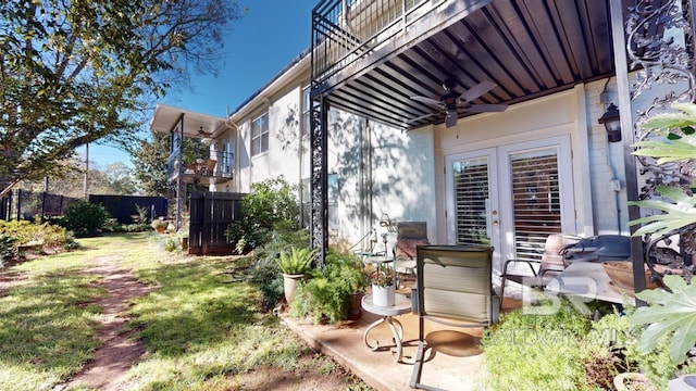 view of yard with ceiling fan and a balcony