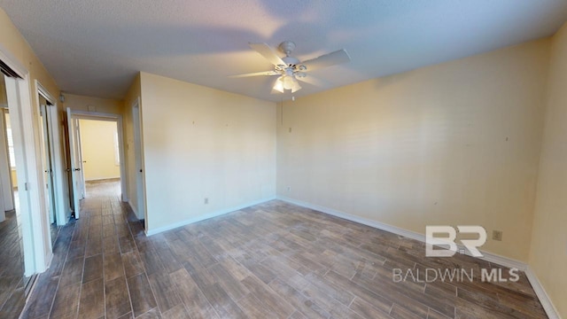 spare room with ceiling fan, dark wood-type flooring, and a textured ceiling