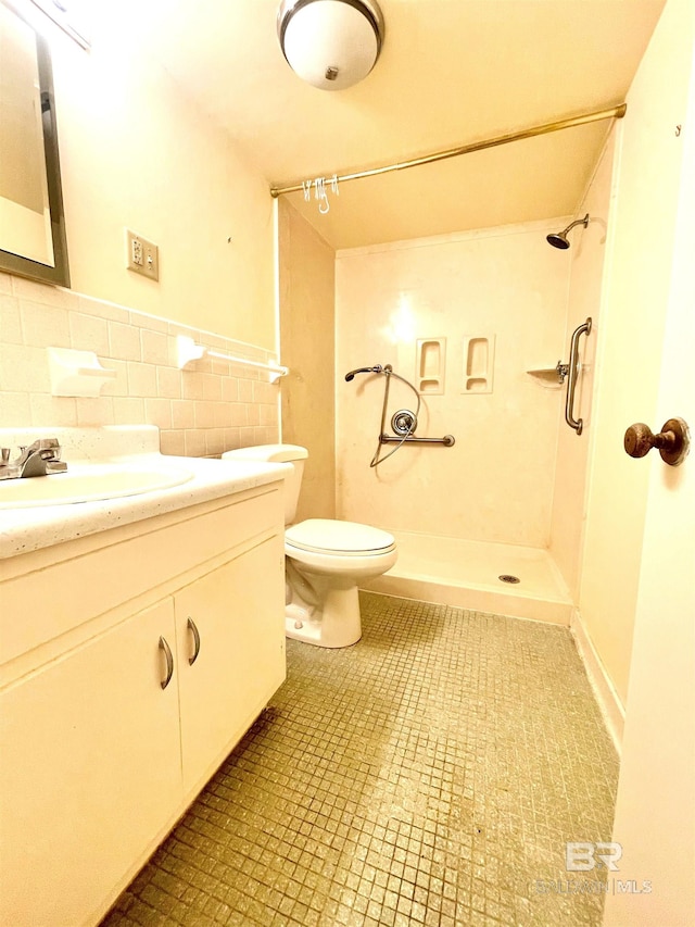 bathroom with tile patterned flooring, vanity, toilet, and walk in shower