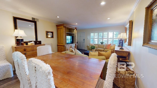 dining area featuring hardwood / wood-style flooring and ornamental molding