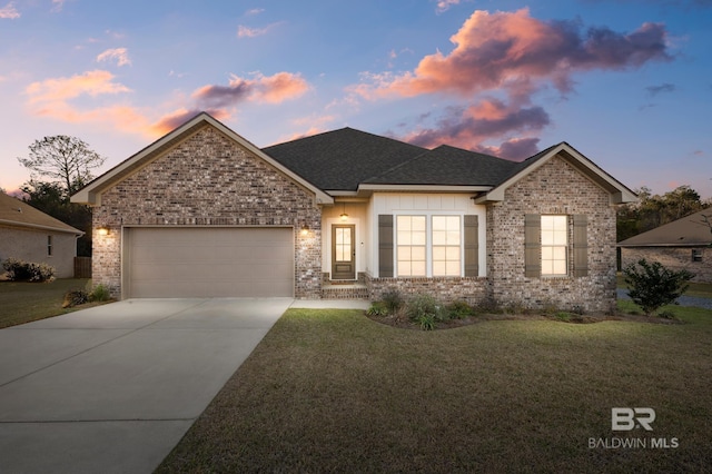 single story home with driveway, roof with shingles, an attached garage, a yard, and brick siding