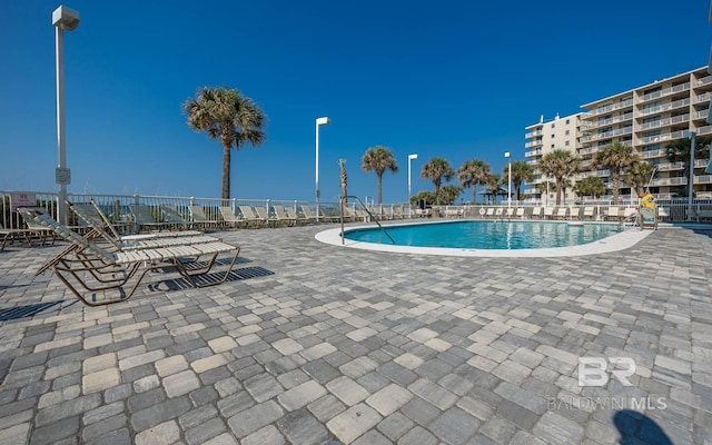 community pool featuring a patio and fence