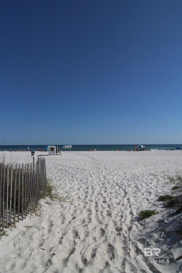 water view featuring fence and a view of the beach