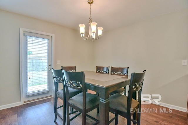 dining area featuring an inviting chandelier, wood finished floors, and baseboards