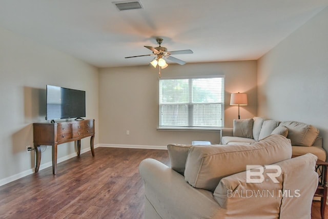living room with visible vents, baseboards, ceiling fan, and dark wood-type flooring