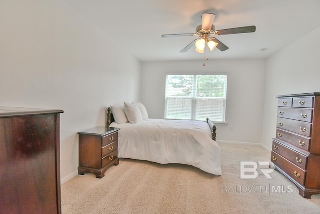 bedroom featuring light colored carpet, baseboards, and ceiling fan