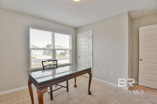 office space featuring baseboards and light carpet