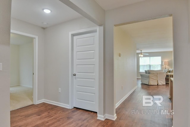 hall with wood finished floors and baseboards