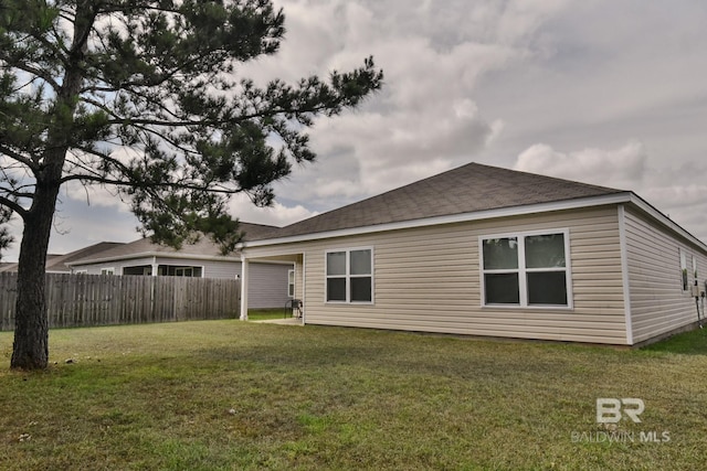 rear view of property with a yard and fence